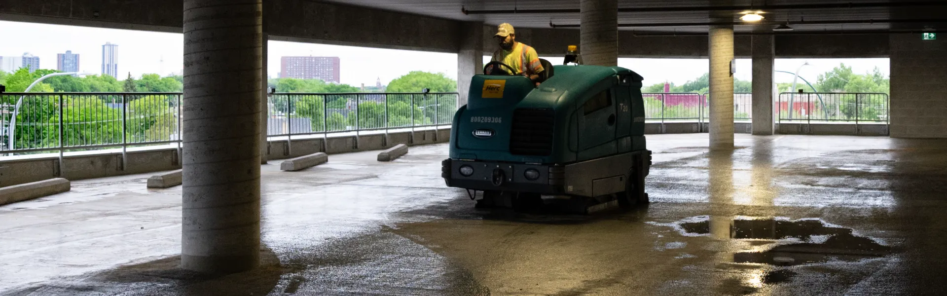 Ride-on scrubber cleaning a covered parkade in Winnipeg